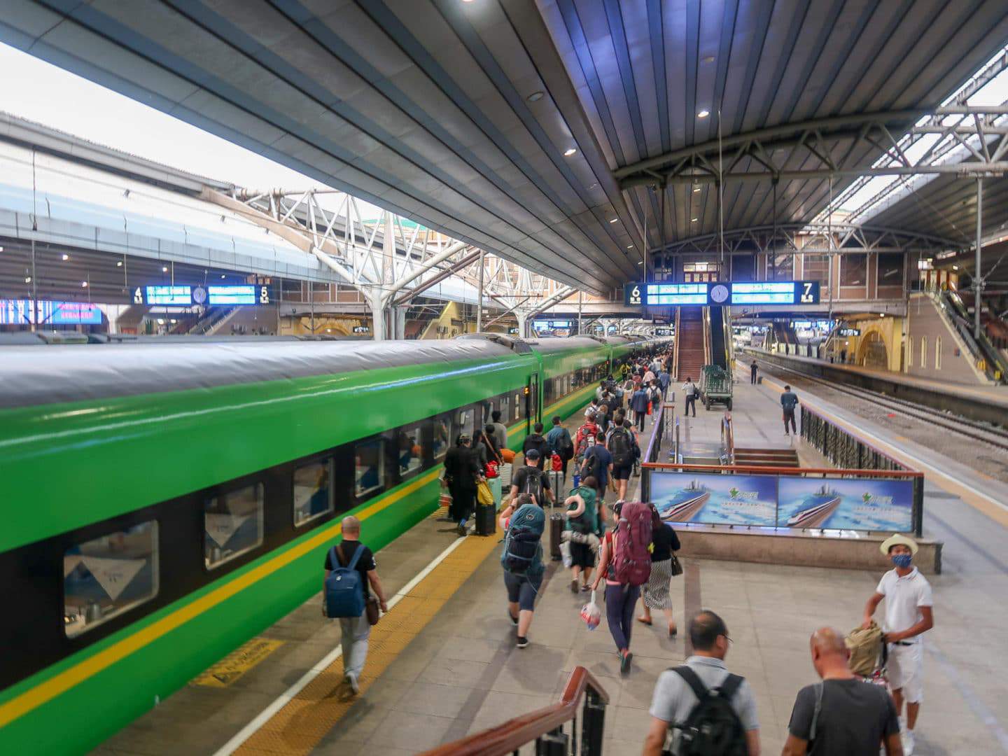 train travel in china, green train on platform in china train station