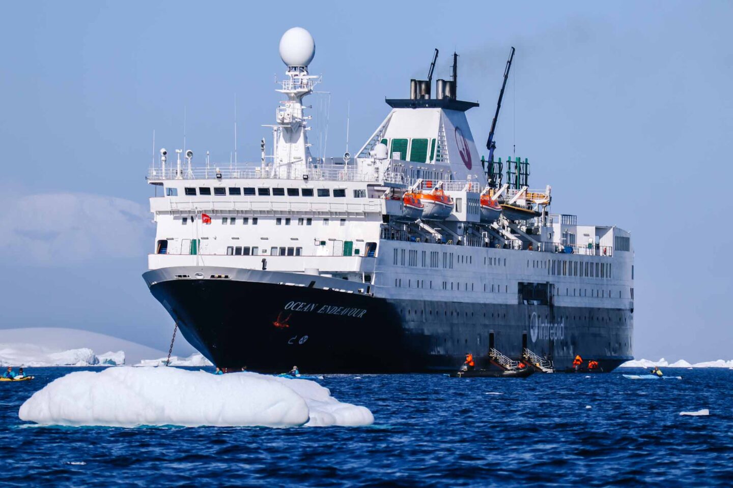 Antarctica in November, Best time to visit Antarctica, ship and sea kayakers in water with blue sky - Antarctica in November, Best time to visit Antarctica, ship and sea kayakers in water with blue sky