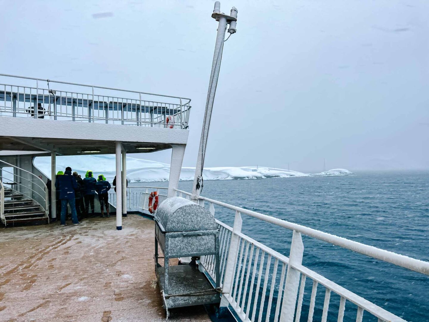 Antarctica in November, Best time to visit Antarctica, ship with snow and icebergs behind - Antarctica in November, Best time to visit Antarctica, ship with snow and icebergs behind