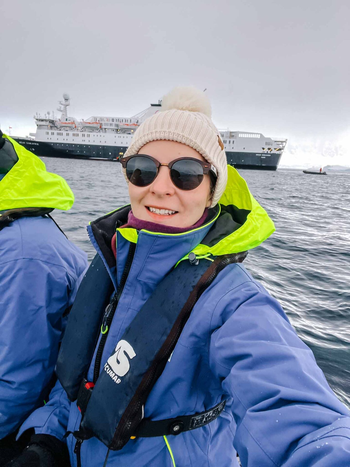 Ellie with hat, sunglasses and buff on in Antarctica, What to wear in Antarctica, What to pack for Antarctica, - Ellie with hat, sunglasses and buff on in Antarctica, What to wear in Antarctica, What to pack for Antarctica,