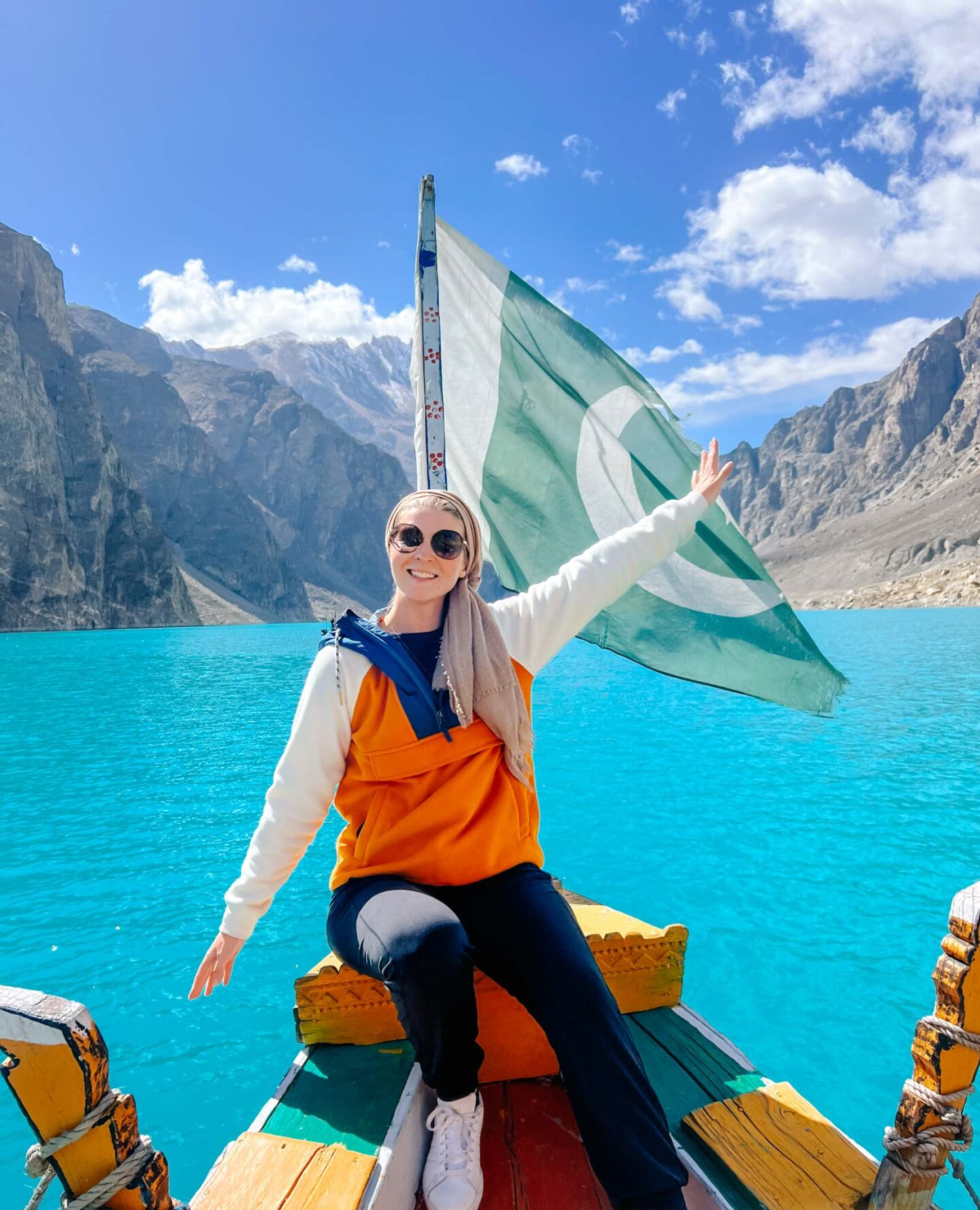 Ellie on Attabad lake with Pakistan flag, what to wear in Pakistan - Ellie on Attabad lake with Pakistan flag, what to wear in Pakistan