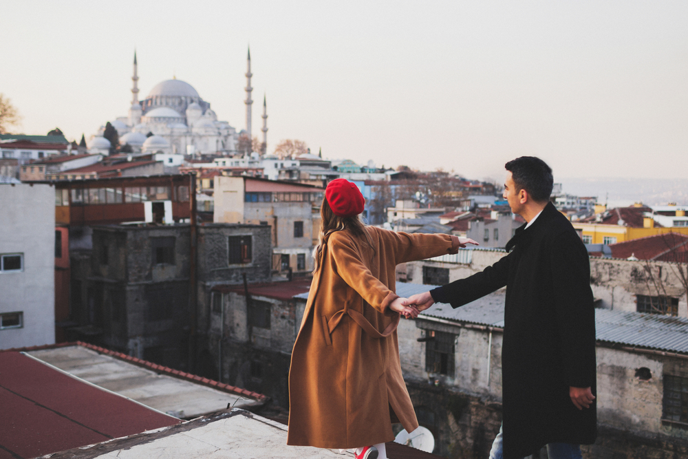 what to wear in Turkey, couple in coats in Istanbul by mosque - what to wear in Turkey, couple in coats in Istanbul by mosque