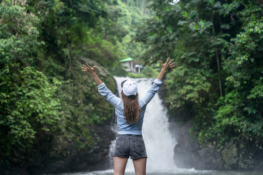 Packing List Bali, woman in activewear in Bali at waterfall - Packing List Bali, woman in activewear in Bali at waterfall
