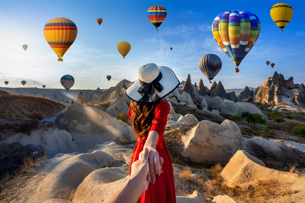what to wear in Turkey, woman in red dress infront of hot air balloons in Cappadocia - what to wear in Turkey, woman in red dress infront of hot air balloons in Cappadocia