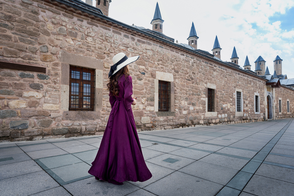 what to wear in Turkey, woman in long purple dress outside mosque in Konya - what to wear in Turkey, woman in long purple dress outside mosque in Konya