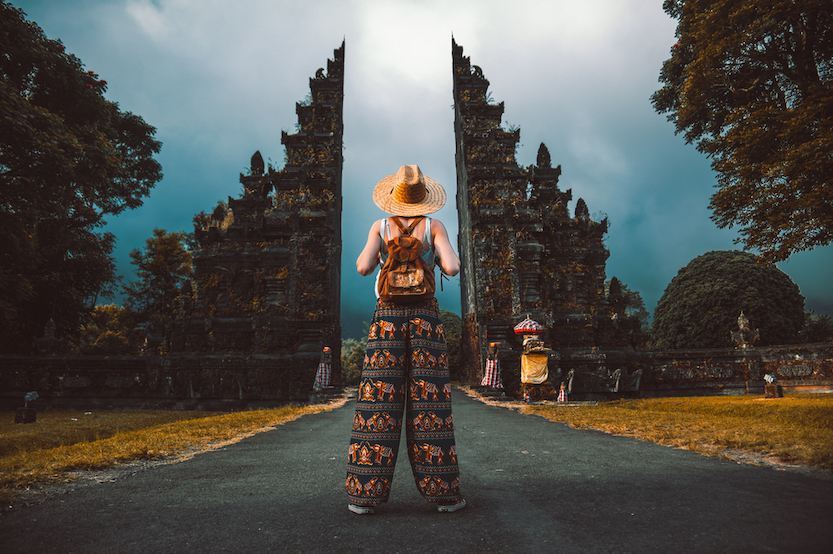 Packing List Bali, female at temple gates in Bali in elephant pants - Packing List Bali, female at temple gates in Bali in elephant pants