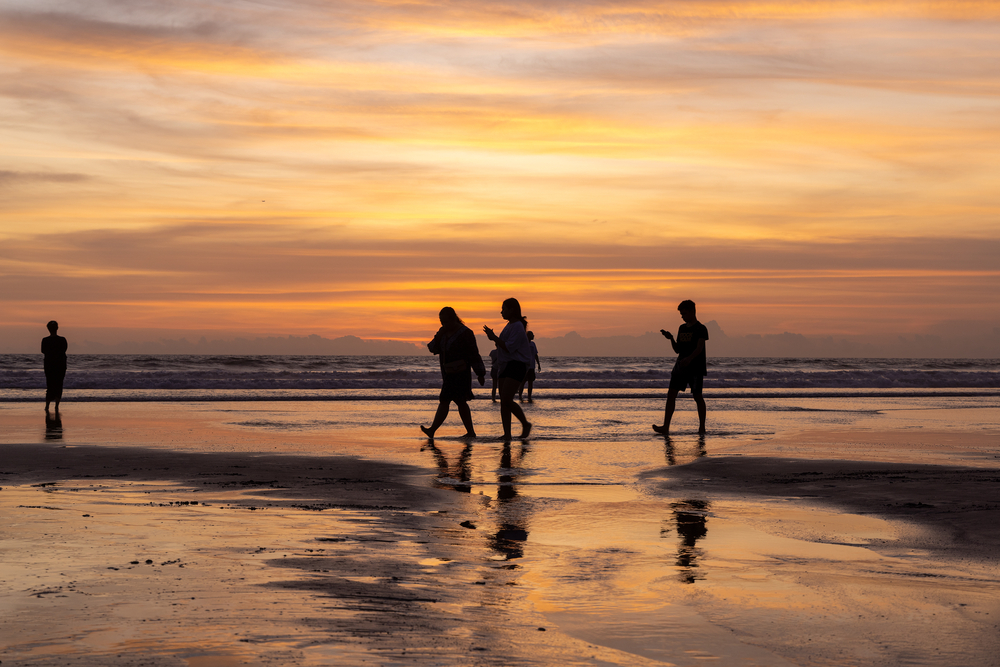 Packing List Bali, tourists on beach in Bali at sunset - Packing List Bali, tourists on beach in Bali at sunset