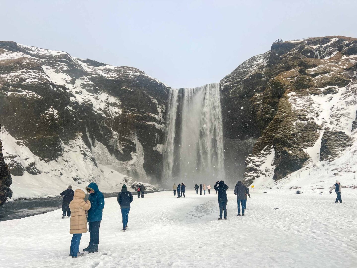 what to wear in Iceland in winter, tourists at waterfall in iceland in winter clothes - what to wear in Iceland in winter, tourists at waterfall in iceland in winter clothes