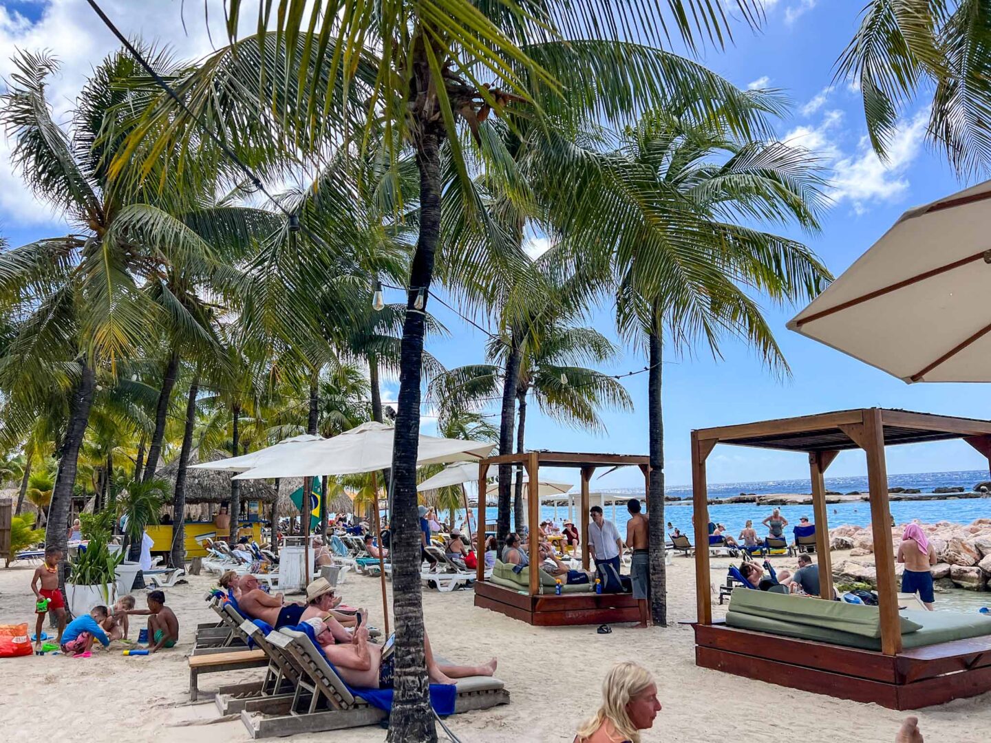 how to see islands on a Caribbean cruise, Mambo Beach busy with sunbeds - how to see islands on a Caribbean cruise, Mambo Beach busy with sunbeds