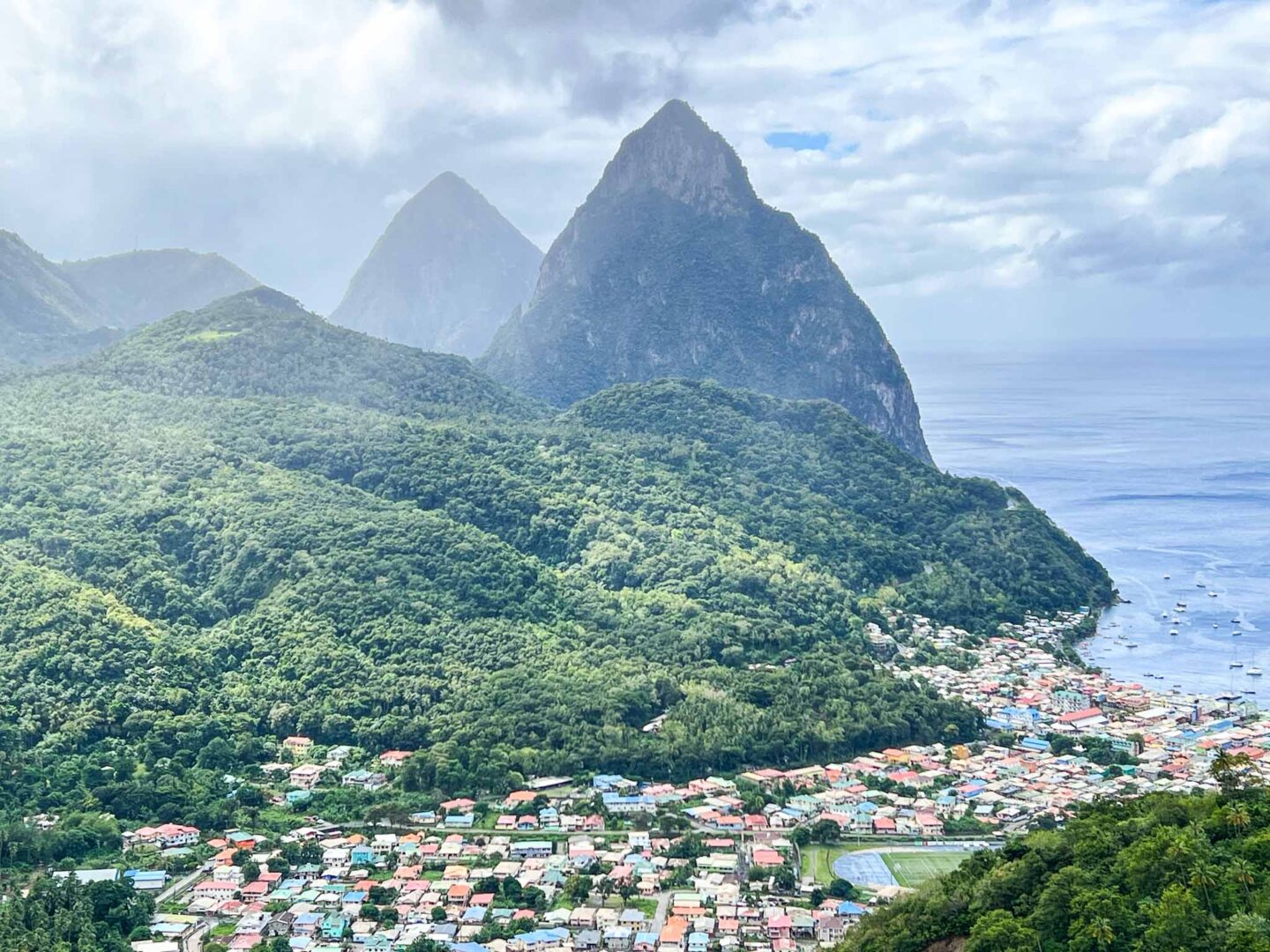 how to see islands on a Caribbean cruise, St Lucia pitons with village below - how to see islands on a Caribbean cruise, St Lucia pitons with village below