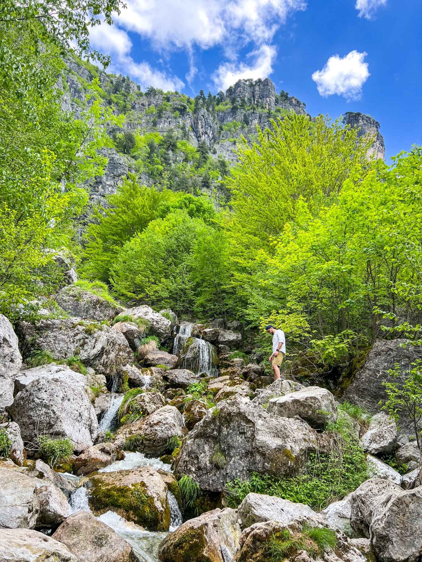 one day in Theth Albania, man standing at Theth Waterfall - one day in Theth Albania, man standing at Theth Waterfall