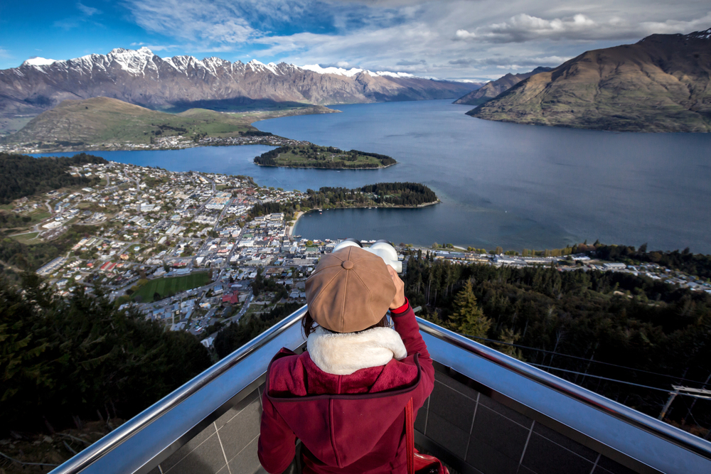 best countries to visit in June, woman overlooking Queenstown in winter